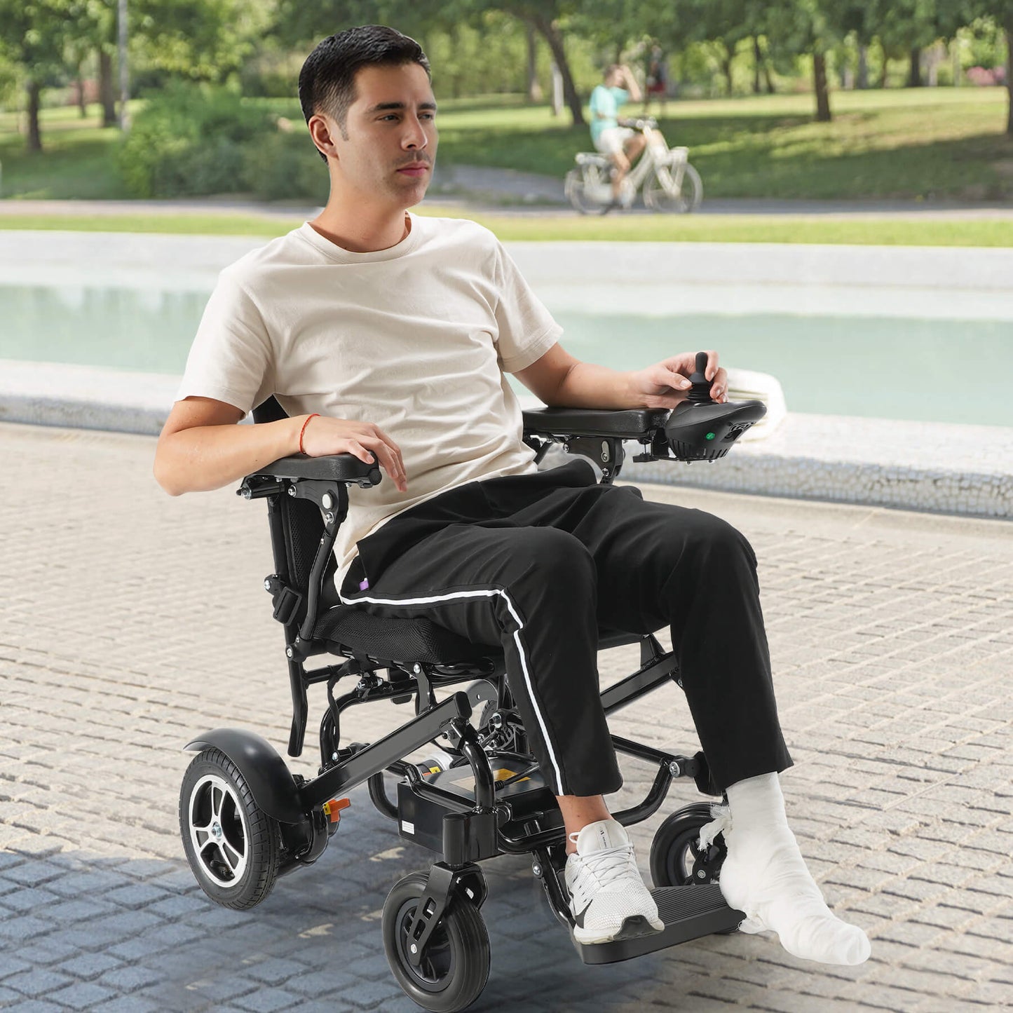 A man recovering from a foot injury is using a power wheelchair to relax outside.